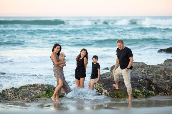 Famille les pieds dans l'eau à la plage