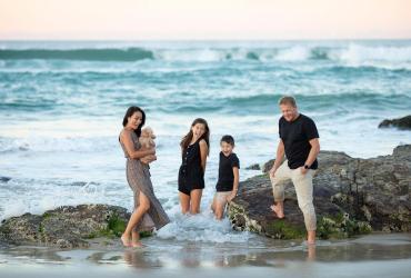 Famille les pieds dans l'eau à la plage 